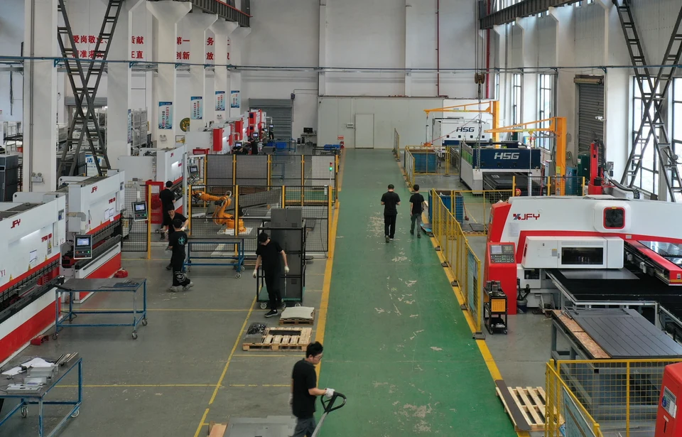 Factory metalworking area with an orange bending robot